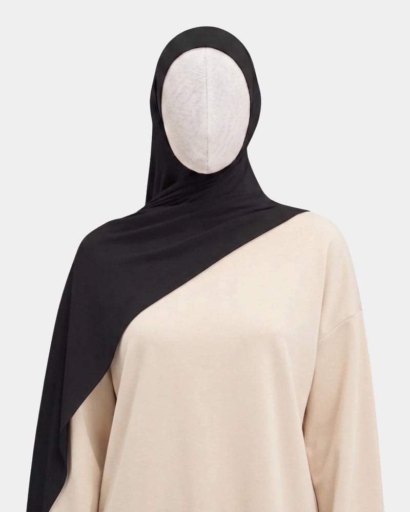 Hijab modal breathable noir porté de face, encadrant le visage, tissu doux et respirant