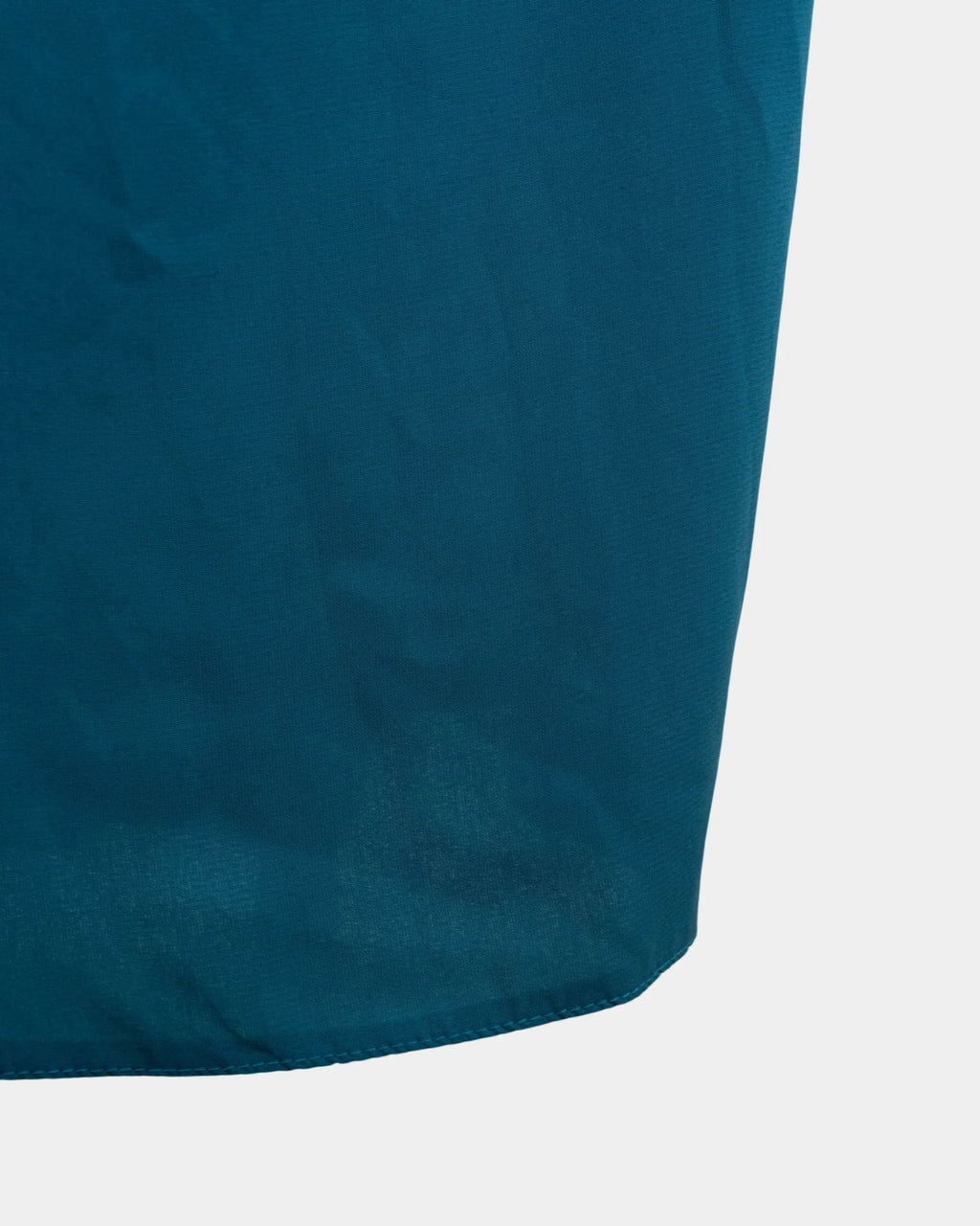 Bas du jilbab bleu canard, ourlet surpiqué et finition arrondie du tissu