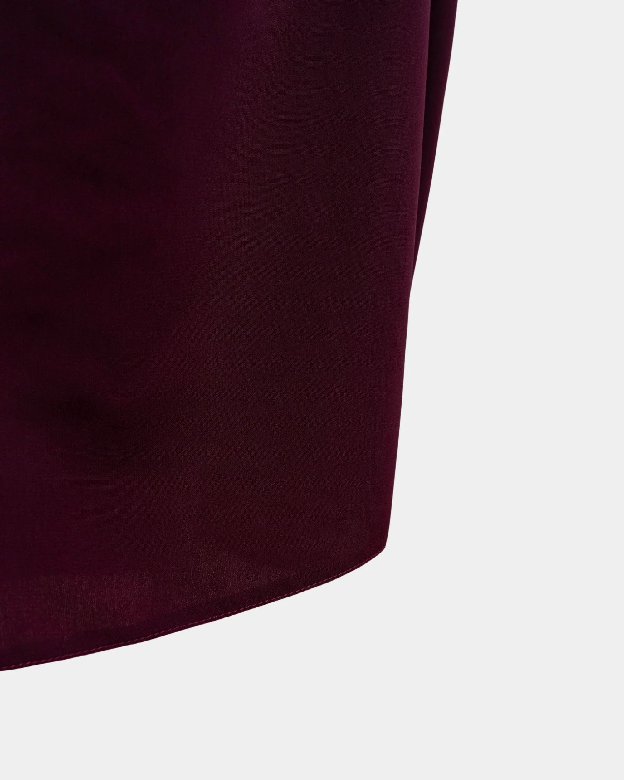Bas du jilbab bordeaux, ourlet surpiqué et finition arrondie du tissu
