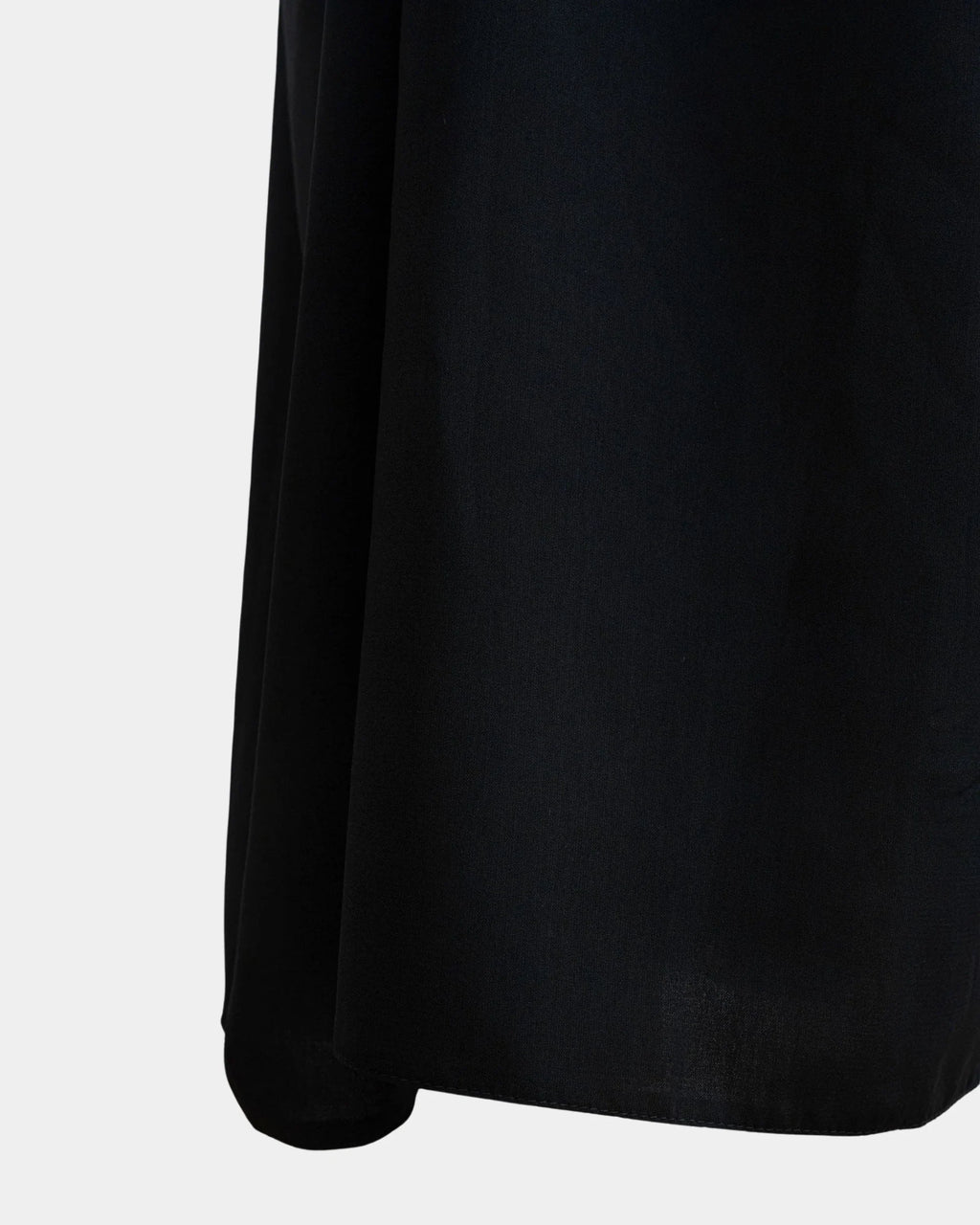Bas du jilbab noir, ourlet surpiqué et finition arrondie du tissu