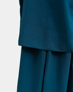 Ourlet du khimar bleu canard retombant sur la jupe assortie, finition surpiquée