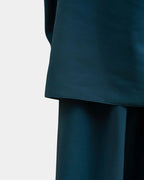 Ourlet du khimar bleu pétrole retombant sur la jupe assortie, finition surpiquée