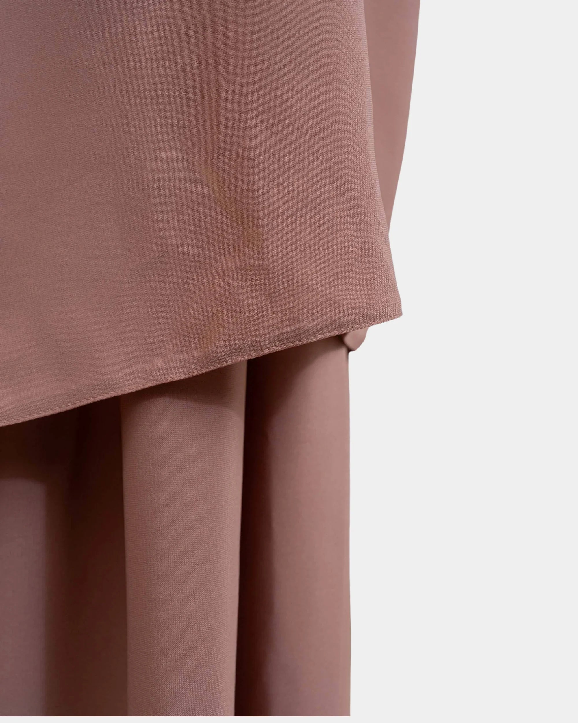 Ourlet du khimar camel retombant sur la jupe assortie, finition surpiquée