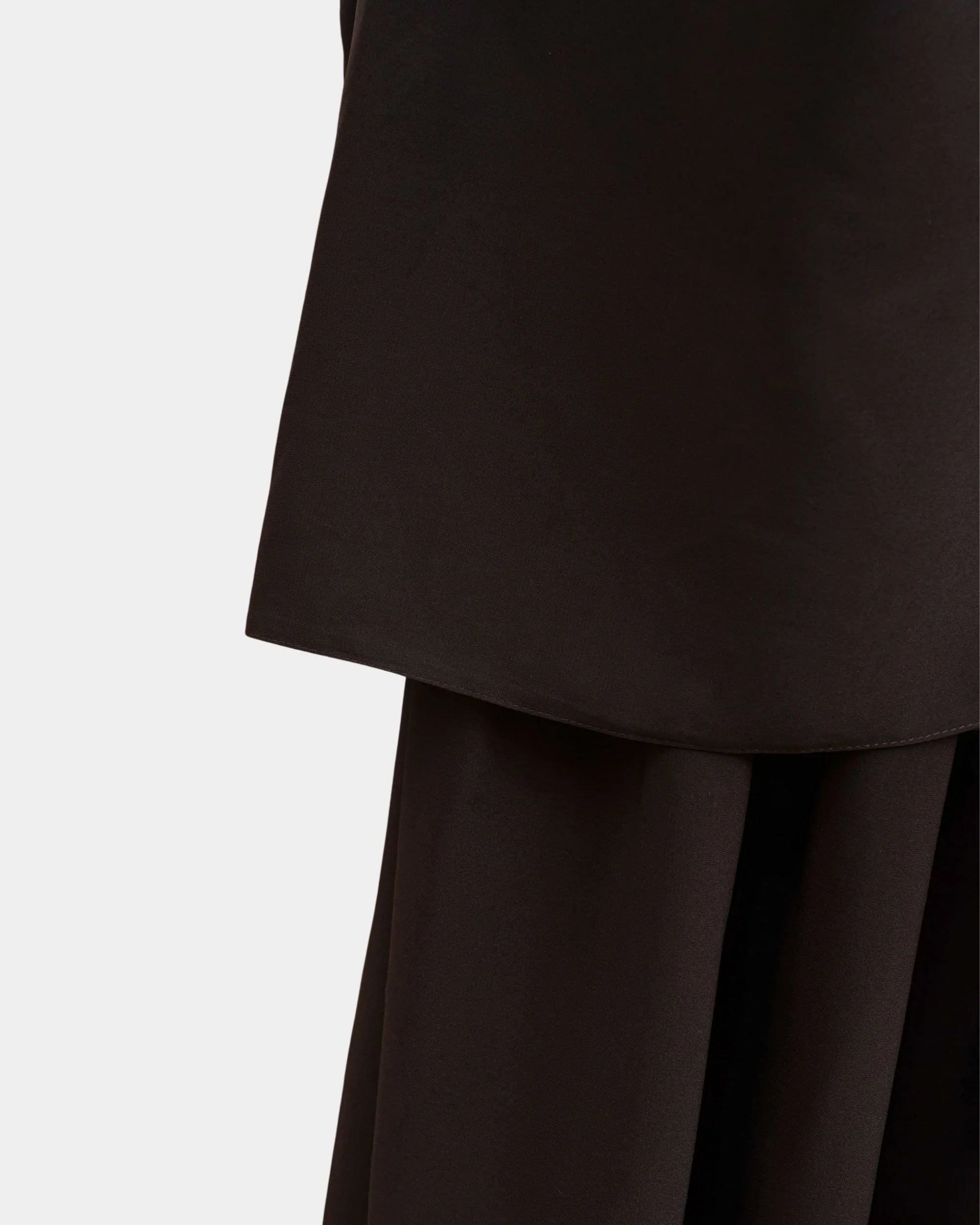 Ourlet du khimar marron café retombant sur la jupe assortie, finition surpiquée