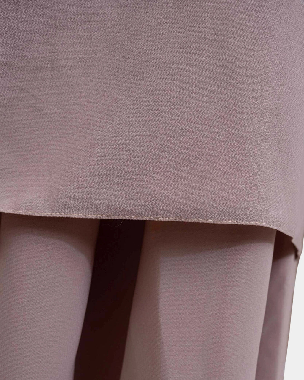 Ourlet du khimar taupe clair retombant sur la jupe assortie, finition surpiquée