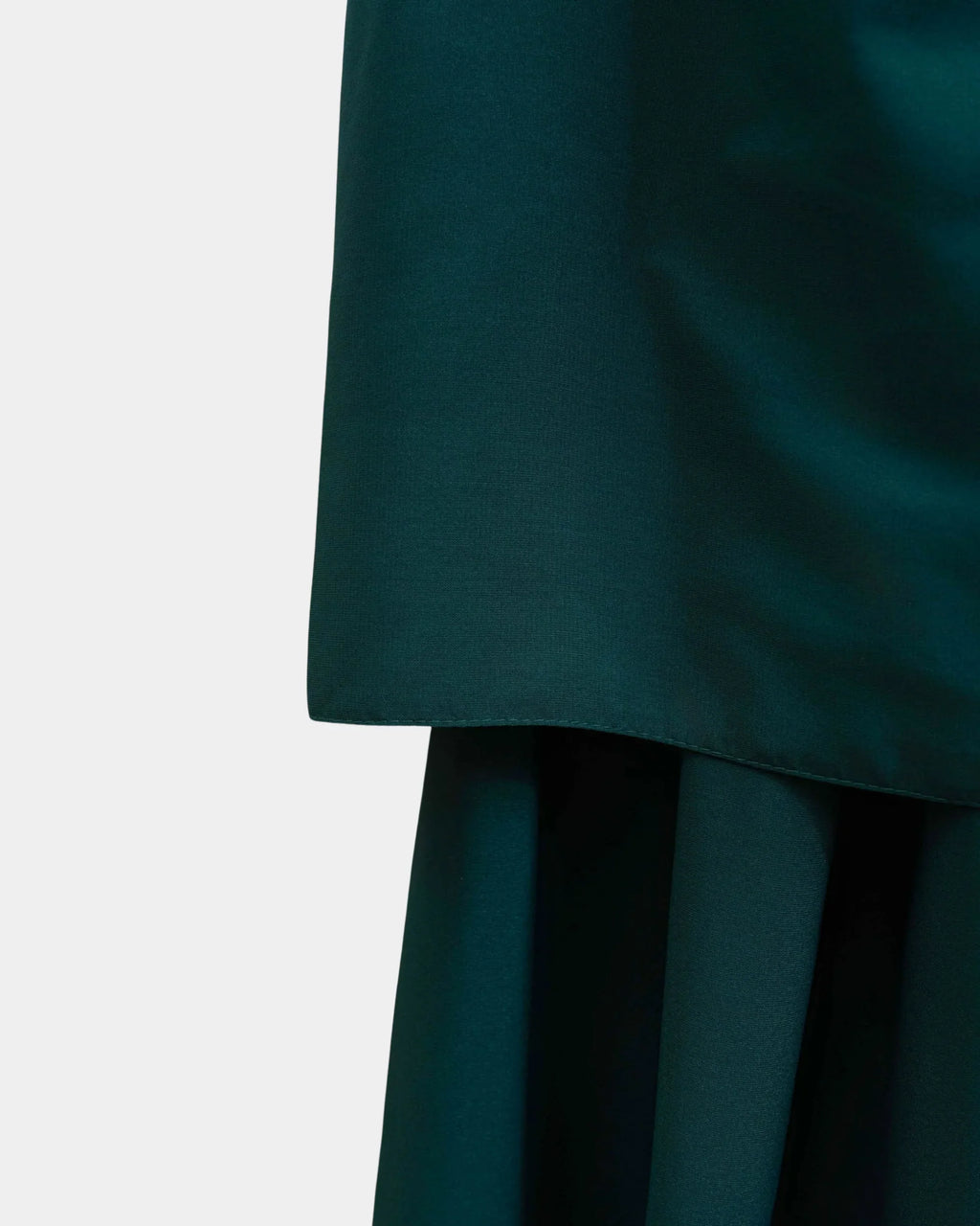 Ourlet du khimar vert forêt retombant sur la jupe assortie, finition surpiquée