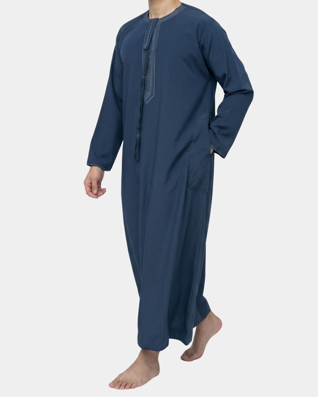 Homme portant le qamis émirati bleu marine Al Rezam, vue de profil