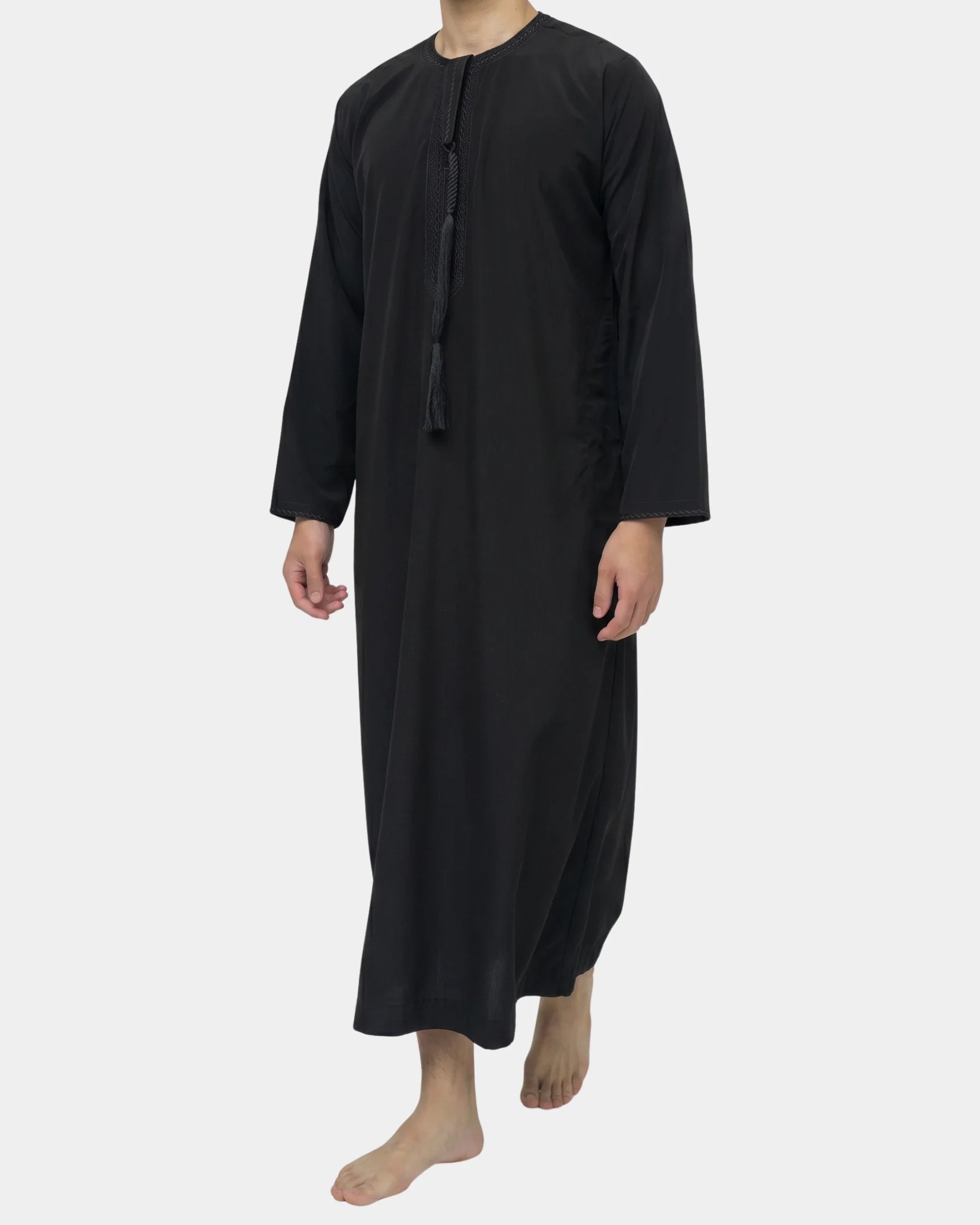 Homme portant le qamis émirati noir Al Rezam, vue de profil