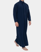 Homme portant le qamis qatari bleu marine Al Rezam, vue de profil