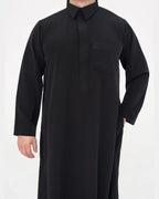 Qamis qatari noir Al Rezam porté de face, col chemise et poche poitrine