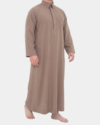 Homme portant le qamis qatari taupe Al Rezam, vue de profil
