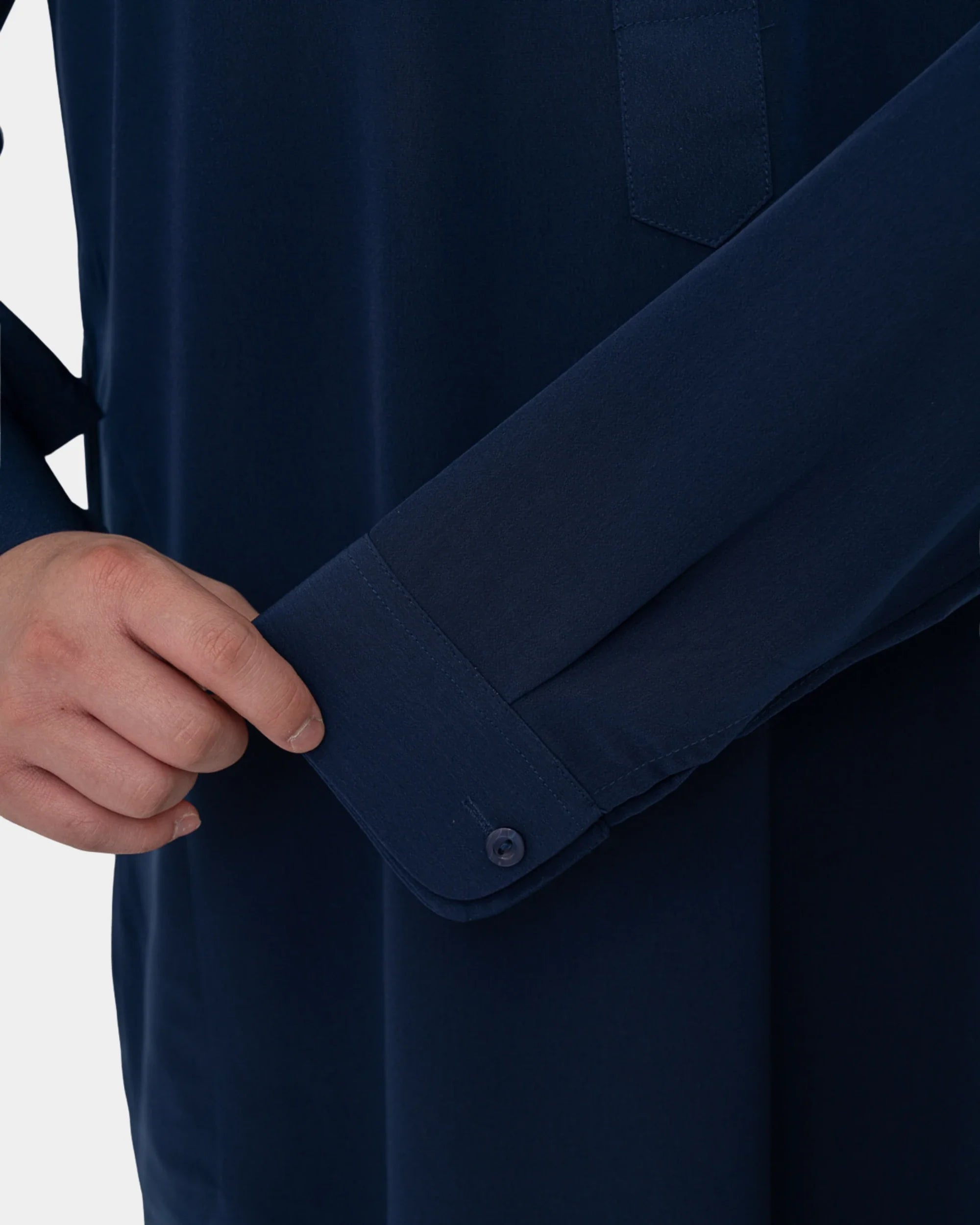Détail de la manchette boutonnée du qamis saoudien enfant à manchettes bleu marine Al Rezam
