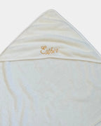 Détail de la broderie du prénom en fil doré sur la capuche de la serviette de bain bébé
